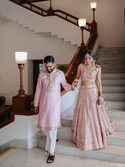 The couple making their entrance at the Mehendi event, looking elegant in their coordinated pink outfits.
