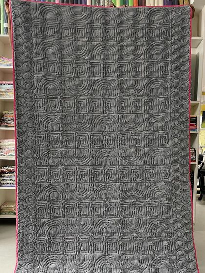 The back of the Graffiti quilt, featuring a complex, geometric quilting pattern.