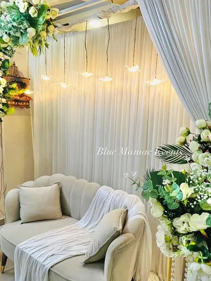 This view captures the full ambiance of the Roka setup, with the soft drapes, warm lighting, and lush florals creating a cozy and elegant corner for the couple.