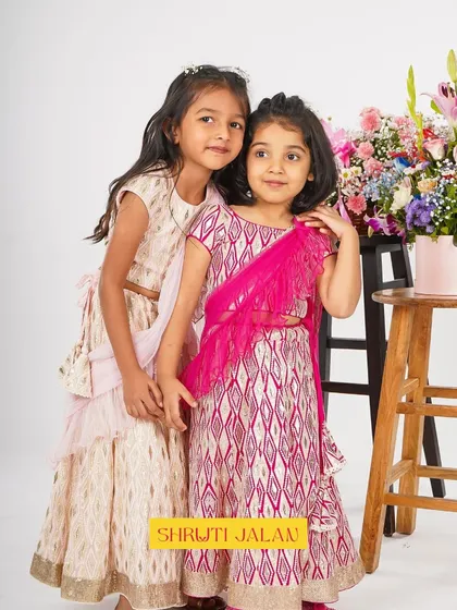 Two sisters posing in their printed lehengas. The soft colors and comfortable fit make these perfect for long events.