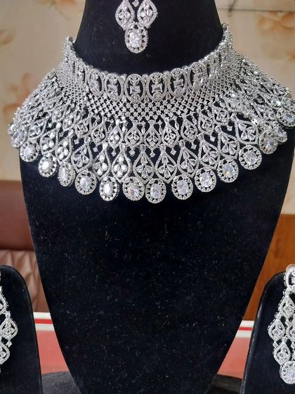 A wide, intricate American Diamond choker set with matching earrings and maang tikka.