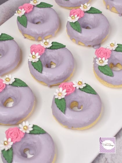 A closer view of the floral baked donuts. The small flowers are all handmade and add a touch of elegance to the dessert spread.