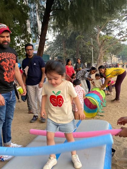 A perfect moment from a fitness-themed birthday party. A toddler navigates a simple obstacle course with help from our coaches and encouragement from dad, building confidence with every step.