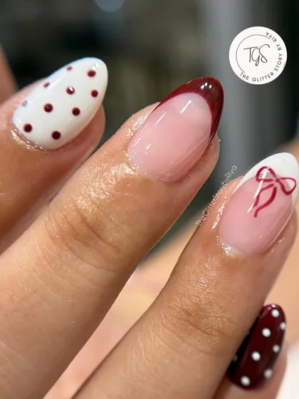 A close-up of the mixed-and-matched set, highlighting the crisp lines of the red French tip and the fine detail of the bow.