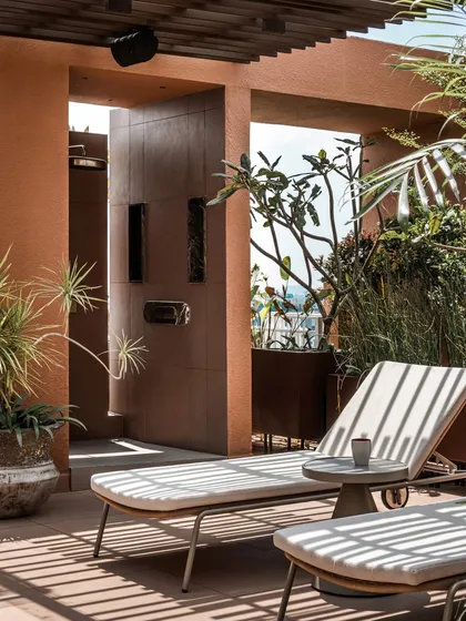 A private nook designed for ultimate relaxation at the Terra Gardens penthouse. This dedicated spa area, complete with sun loungers and an outdoor shower, offers a serene escape, transforming the terrace into a personal holiday retreat within the city.
