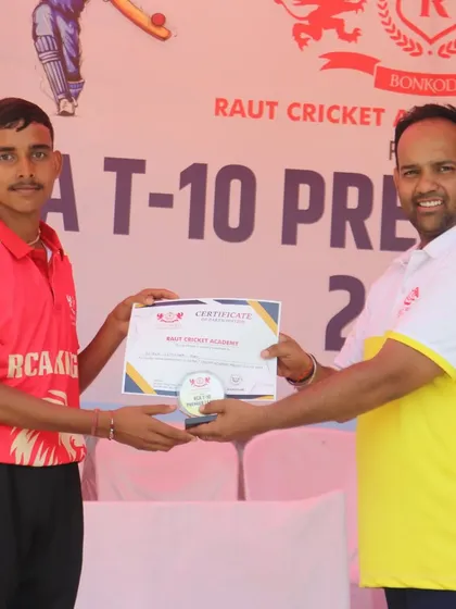 A young champion from the RCA Kings team is awarded his participation certificate.