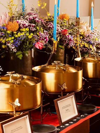 A closer look at the elegant gold serveware and vibrant floral arrangements that accompany our modern Indian buffet service.