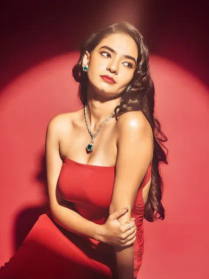 A close up on the jewelry styling for Anushka Sen's Elle shoot. The emerald green earrings and delicate necklace add a pop of contrasting color to the red gown, creating a sophisticated look.