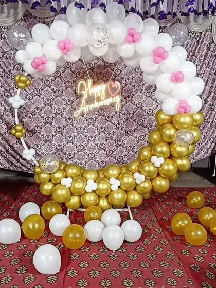 The full anniversary balloon hoop setup, with loose balloons scattered on the floor for a playful effect.