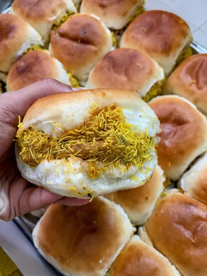 A close-up of a Kutchi Dabeli, showing the delicious filling.