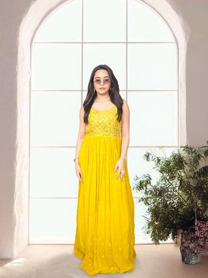 A bright yellow anarkali-style gown is perfect for a Haldi or Mehendi function. It's cheerful, elegant, and photographs beautifully.