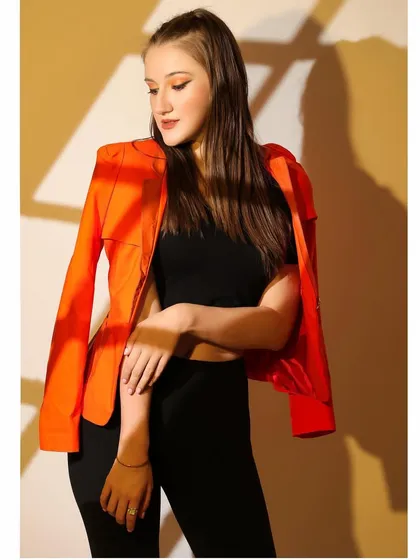 Another shot from the gobo series, with the model in a bright orange jacket creating a strong color contrast.