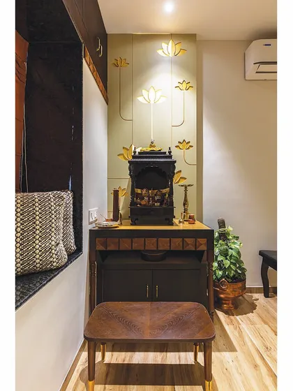 This traditional puja mandir is set against a feature wall with golden lotus motifs, creating a divine and tranquil corner in the grandfather's room.