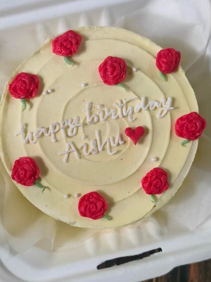 A simple yet beautiful floral bento cake. This design features piped red roses scattered across a cream-colored base with a "Happy Birthday" message written in the center.