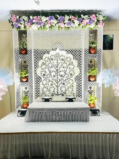 Here is an elegant, white-themed Ganpati decoration for a client's home. The centerpiece is a custom Tree of Life Jaali backdrop, complemented by a raised platform for the idol and built-in niches to display small plants and diyas.