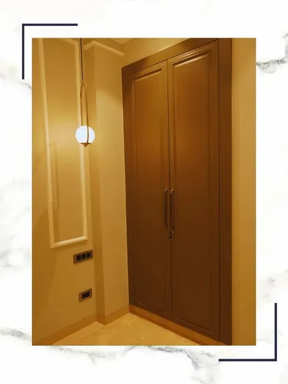 A minimalist wardrobe design with sleek, handleless doors and a modern pendant light. This style is perfect for creating a clean and uncluttered look in your bedroom.