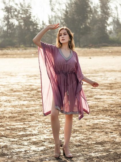 Styling a sheer purple kaftan for a seaside chic look. The lightweight fabric and simple silhouette are perfect for a vacation wardrobe.