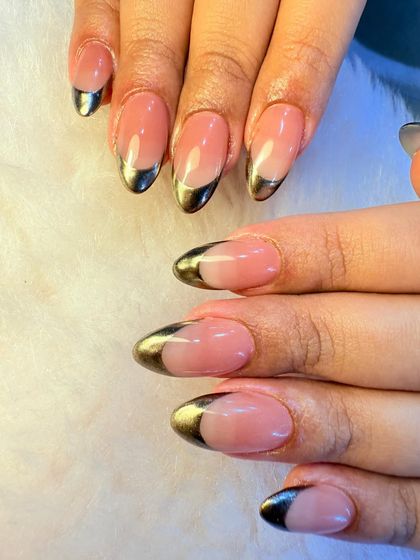 A classic chrome French manicure. This look features a beautiful nude base with a striking gold chrome tip, offering a glamorous and bold alternative to the traditional white French.