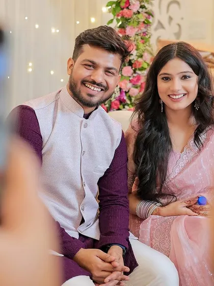 A happy portrait of a couple at their Roka, captured through the frame of two smartphones.