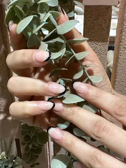 The contrast between the sheer pink base and the deep black tip makes this modern French manicure incredibly striking.