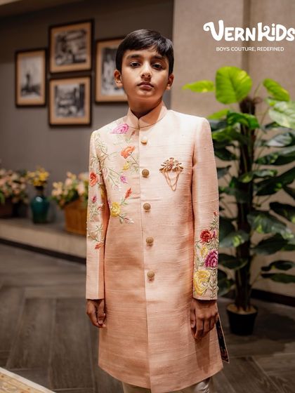 Our floral embroidered sherwani in soft peach, is a perfect example of elegance. The full-length view showcases the beautiful drape of the fabric and the artful placement of the hand embroidery.
