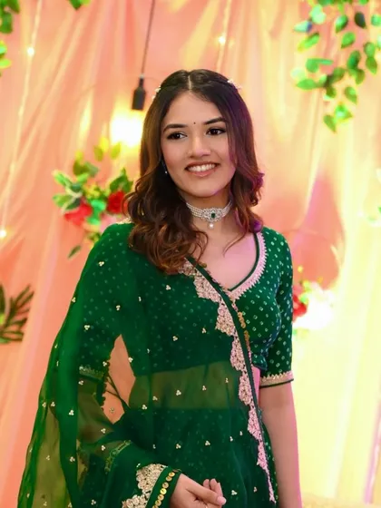 Another shot of Dhruvi looking adorable at her Kankotri ceremony. Her smile and the fresh green of her outfit are a perfect match.