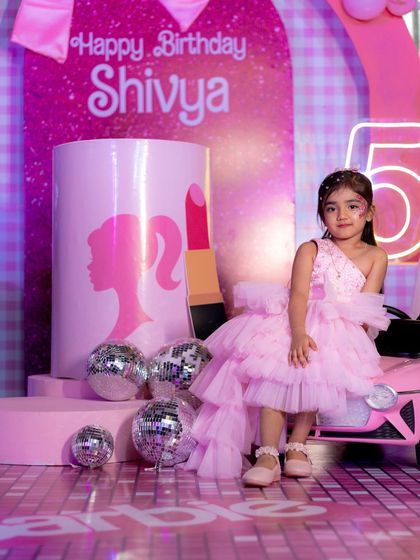 The birthday girl posing like a true star next to a giant lipstick prop and disco balls.