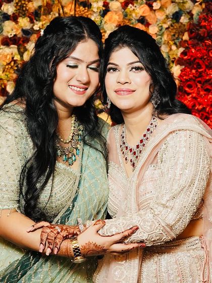 A happy, candid moment between two clients. Both have flawless makeup that enhances their natural beauty.