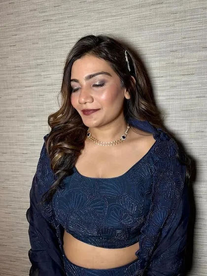 Sparkle in the eyes and soft curls on the side. This is a classic glam look, featuring a beautiful smokey eye with a pop of glitter, perfect for a Sangeet or reception.