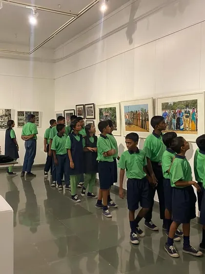 The young students looking at a series of colorful paintings depicting scenes from old films.