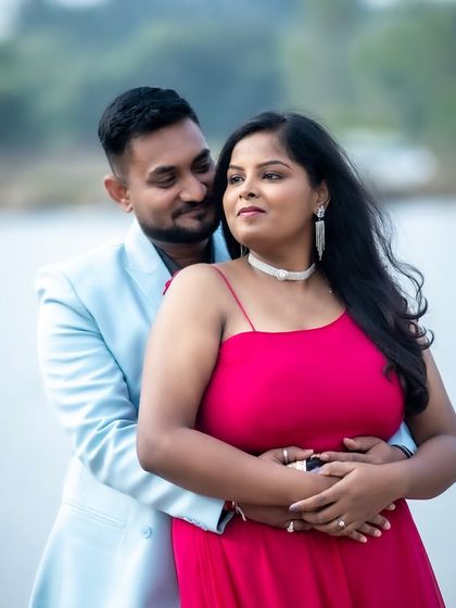 A romantic outdoor shot by the water. The makeup is fresh and radiant, designed to look beautiful in natural daylight, with a pop of color from the bright pink dress.