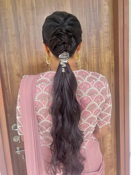 A modern ponytail with a braided detail and a stylish hair cuff.