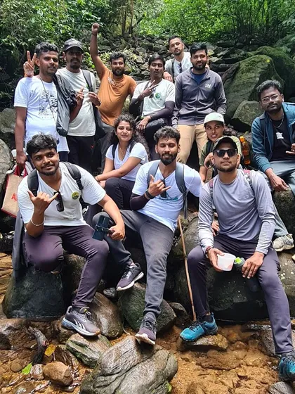 A group takes a break on the rocks along the Kumara Parvatha trail. Staying hydrated and taking rests is key on this long trek.