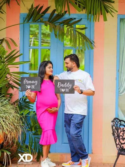 A fun and colorful shot of a couple holding "Mommy to be" and "Daddy to be" signs.