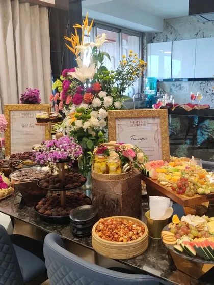 The full view of a lavish grazing table at a private housewarming party. These tables are designed to be a centerpiece, overflowing with a curated selection of sweet and savory treats for guests to enjoy throughout the event.