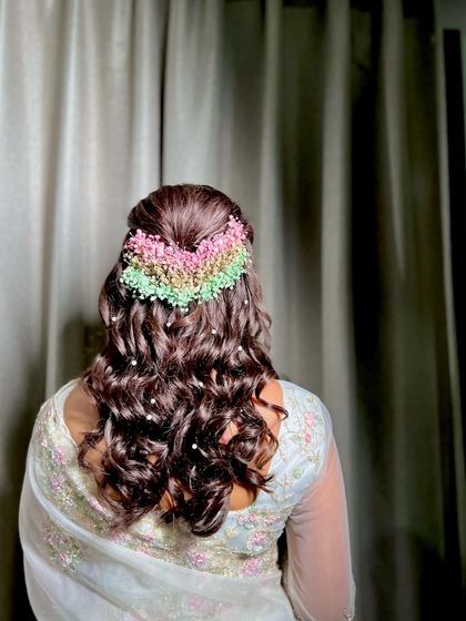 A beautiful half-up style with a rainbow of baby's breath, creating a unique and colorful look for this client.
