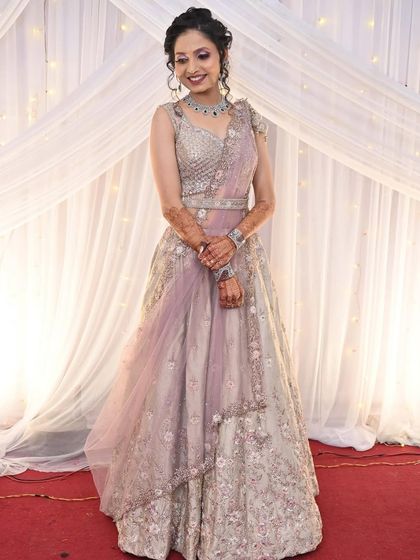 A full shot of the client looking poised and elegant in the lavender and silver lehenga.