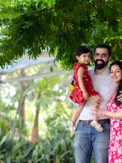 Framed by the beautiful green leaves of a tree, this family shares a loving moment. Natural settings create a serene and timeless feel for family photography.