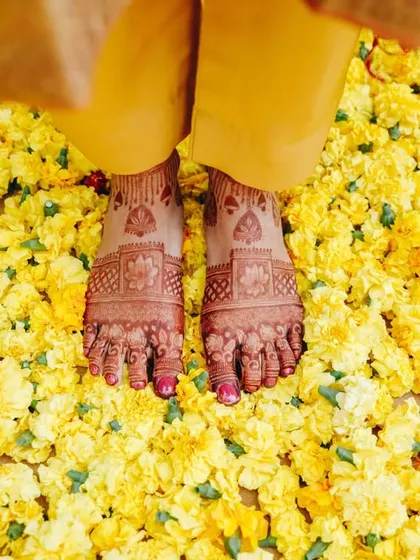A beautiful detail shot of the bride's feet on a bed of fresh marigold flowers. It's these small, beautiful moments that make a Haldi ceremony so special.