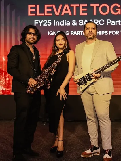 A formal shot of our trio against the event backdrop. We ensure our look and stage presence align perfectly with the professional setting of your event.