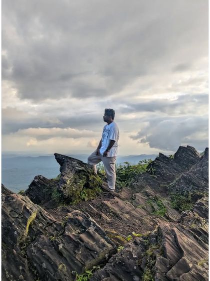 Standing on the rocky outcrops of a Chikmagalur peak, feeling the wind and admiring the vast landscape below. These are the moments of connection with nature that we seek on every trek.
