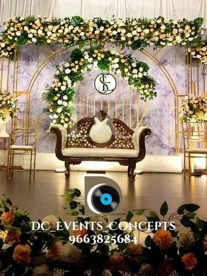 A full view of the sophisticated reception decor, showing how the stage design integrates with the overall venue. The foreground florals add depth, making the entire setting feel immersive and luxurious.