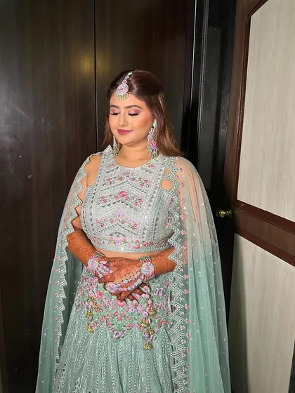 Crafting a radiant glow for Riddhi's mehendi. This look features a pop of color on the lips and soft, shimmery eyes to match her mint green outfit.