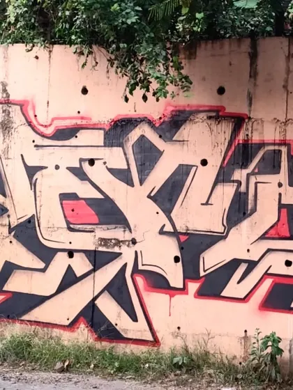 A different angle of the "Dkrypt This" piece, showing how the letters interact with the rough texture of the wall. The simplicity of the black outline makes the form stand out.