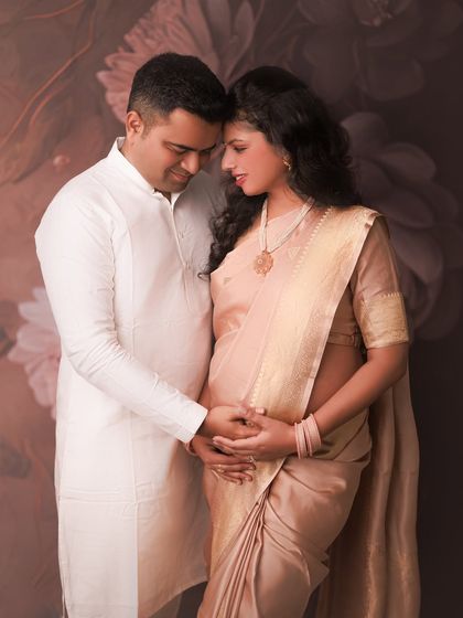 The combination of a soft saree for her and a classic kurta for him creates such a harmonious and elegant portrait. This image speaks of their quiet connection and shared anticipation.