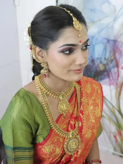 A three-quarter profile of the South Indian bridal look, showcasing the intricate details of the maang tikka and earrings.