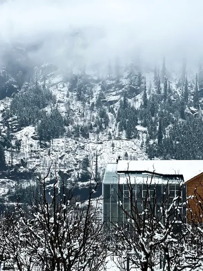 The modern form of the Hamsa Resort's spa building emerges from the misty, forested slopes of Manali. The design juxtaposes a contemporary steel and glass structure with buildings that utilize traditional Kathkuni timber and stone construction.