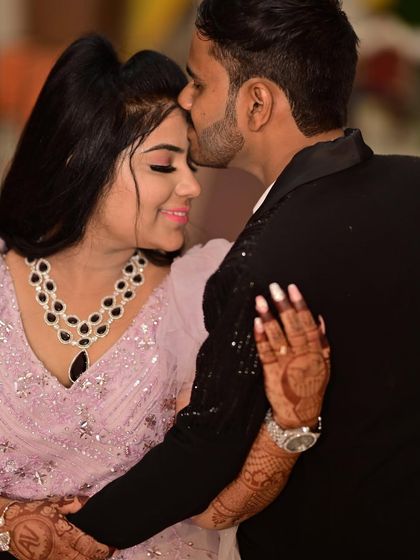 A close-up of a tender moment. This shot highlights the bride-to-be's beautiful makeup, henna, and the sparkling details of her pink engagement gown.