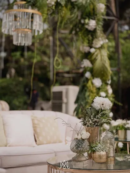 A close-up of the lounge decor, showing the fine details like the crystal chandelier, plush cushions, and delicate floral arrangements on the coffee table.