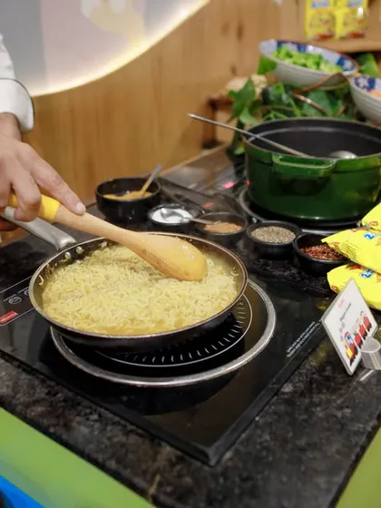 A chef in action at the live Maggi counter, stir-frying noodles to perfection. It's not just food; it's a fun culinary show for your guests.